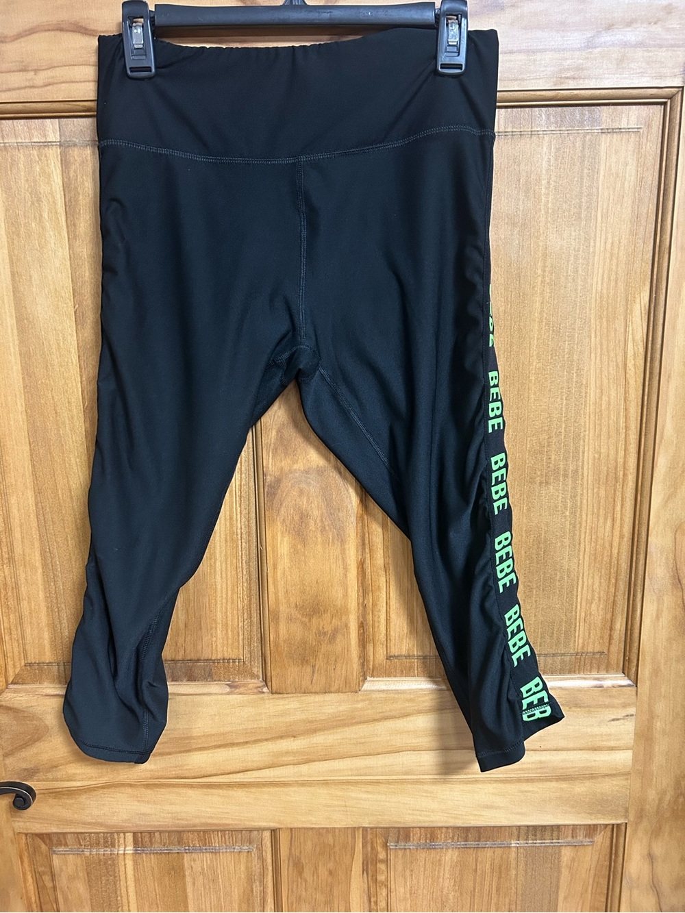 Bebe women’s capris with green logo down legs